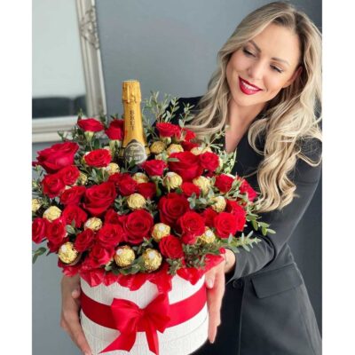 Beautiful Flower Arrangement Decorated with Red Roses, Chocolates, and a Bottle of Champagne