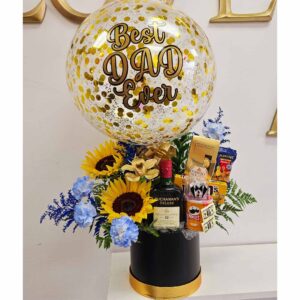 Personalized Surprise Box decorated with beautiful Sunflowers, golden Orchid and blue carnations, filled with goodies and a Bottle of Whiskey (750ml) Decorated with a Beautiful Personalized Balloon