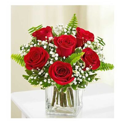 Six lovely red roses, beautifully arranged by our florists with fresh greens in a glass vase